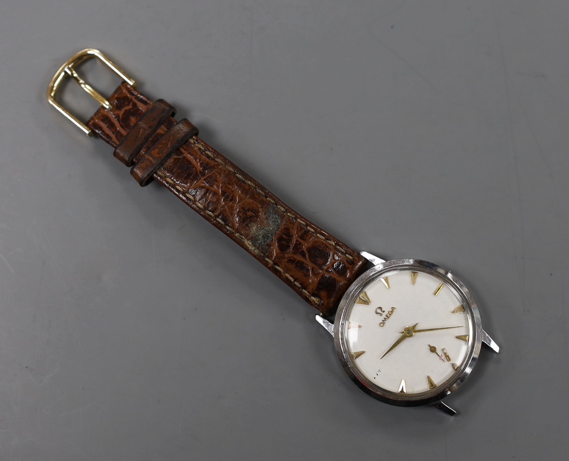 A gentleman's stainless steel Omega manual wind wrist watch, (numeral loose and part of strap missing).